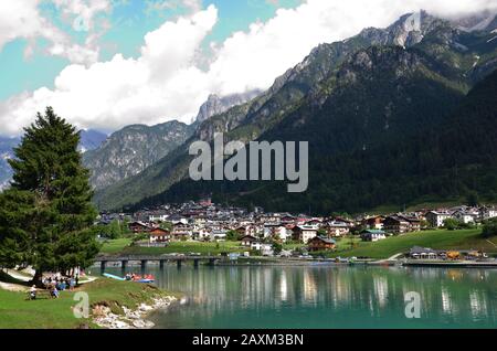 Die Häuser der Stadt Auronzo spiegeln sich in den ruhigen Gewässern des Sees wider Stockfoto