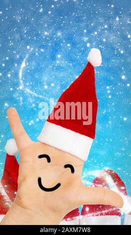 Weihnachtsmann, Hand mit Weihnachtshut und Gesicht vor der Schneeflurry Stockfoto