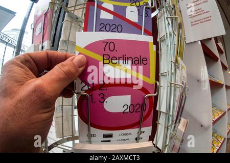 Berlin, Deutschland. Februar 2020. Ein Mann greift nach einer Postkarte mit dem Logo des Filmfestivals der Berlinale. Credit: Paul Zinken / dpa / Alamy Live News Stockfoto