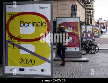 Berlin, Deutschland. Februar 2020. Ein Mann spaziert zwischen den Plakaten der Fimfest-Spiele-Berlinale. Credit: Paul Zinken / dpa / Alamy Live News Stockfoto