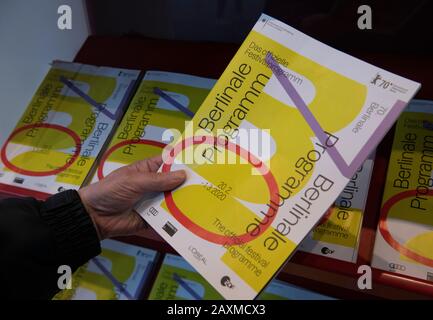 Berlin, Deutschland. Februar 2020. Ein Mann nimmt ein Programmheft des Filmfestivals der Berlinale. Credit: Paul Zinken / dpa / Alamy Live News Stockfoto