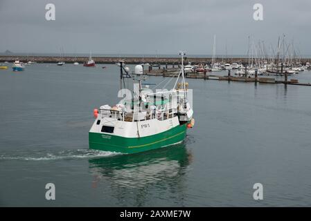 Ein Fischerboot, das den Hafen von Brixham verlässt, einem der größten Fischereihäfen Großbritanniens. Stockfoto