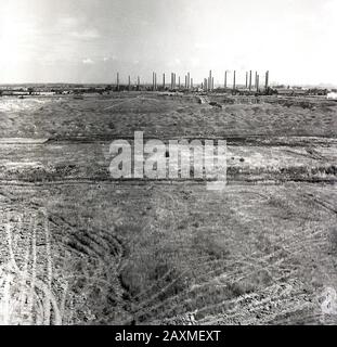 1950er Jahre, historisch, ein Blick über die Landschaft und die Lehmböden des Marston Vale in Richtung der riesigen Stewartby-Ziegelwerke der London Brick Company, Bedfordshire, England, Großbritannien. Im Vale gab es insgesamt 162 Schornsteine, während es in Stewartby 32 Schornsteine gab, die zu dieser Zeit die größte Ziegelei der Welt waren. Das Clayland des Marston Vale ist berühmt für oxford Clay, den Hauptbestandteil des London Brick. Stockfoto