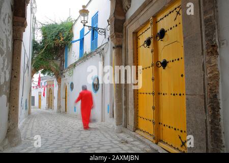 Typische gepflasterte und schmale Straße (dar el Jeld Straße) mit bunten Türen, Säulen und Arkaden in der historischen Medina von Tunis, Tunesien Stockfoto