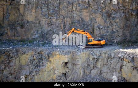 Orangenwürger, der im Steinbruch aus Granit arbeitet Stockfoto
