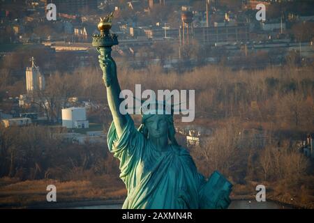 Die Freiheitsstatue vor den Industrievororten von New Jersey, NYC. Stockfoto