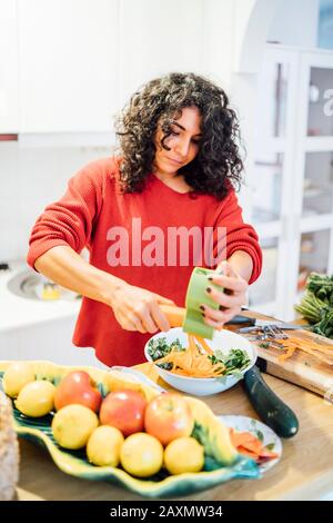 Brunette-Frau, die einen gesunden grünen Salat zubereitet. Stockfoto