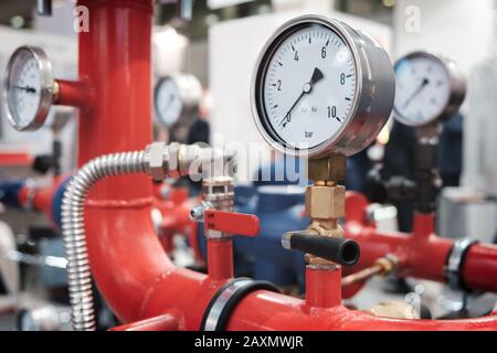 Nahaufnahme von Manometer, Schlauch, Durchflußmesser, Wasser Pumpen und Ventile der Heizungsanlage in einem Kesselraum Stockfoto