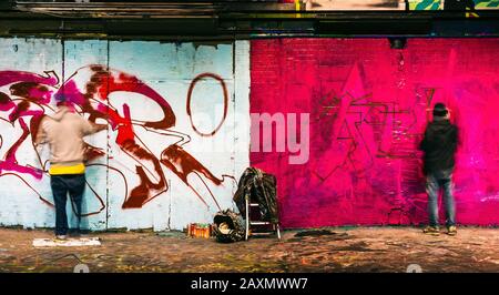 London, Großbritannien/Europa; 21/12/2019: Zwei Graffiti-Künstler malen eine Wand in der Leake Street, London Stockfoto