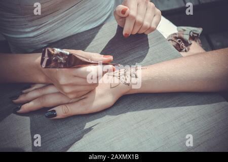 Meister malt ihre Hand mit Henna mehendi in Stilen auf dem Tisch Stockfoto