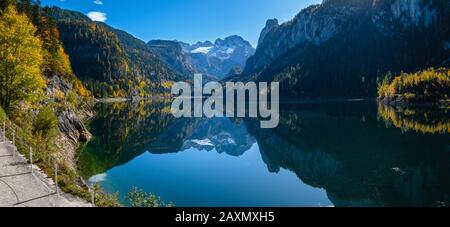 Sonnige idyllische bunten Herbst Alpine View. Friedlichen Berg See mit klarem Wasser und Spiegelungen. Gosauseen oder Vorderer Gosausee, U Stockfoto