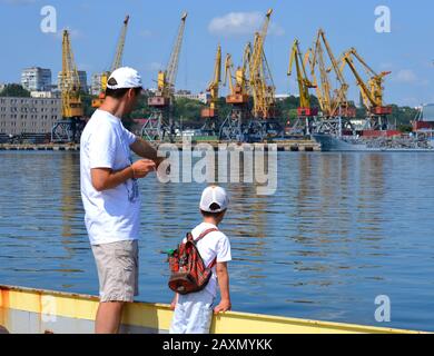 Mann und Kind auf dem Pier in der Nähe des Seehafens. Stadt Odessa, Ukraine 18. Juli 2013 Stockfoto