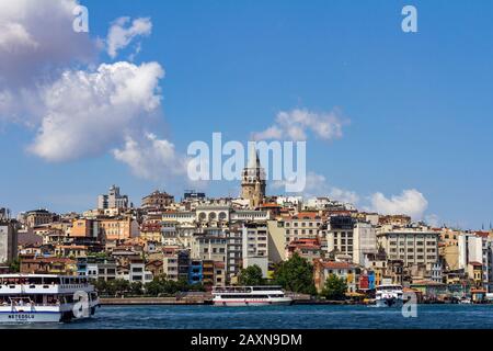 18. Juni 2019 - Istanbul, Türkei - Blick auf den Galata-Turm vom gegenüberliegenden Ufer am Goldenen Horn stehen Fährschiffe im Vordergrund Stockfoto