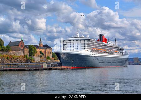 Festung Akershus mit Transatlantikliner Queen Mary 2 im Hafen im Oslo-Fjord, Oslo, Norwegen Stockfoto