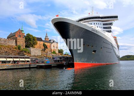 Festung Akershus mit Transatlantikliner Queen Mary 2 im Hafen im Oslo-Fjord, Oslo, Norwegen Stockfoto