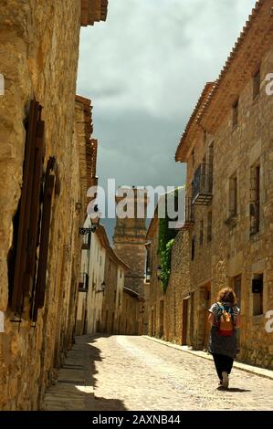 Frau, die durch eine Straße in der Stadt Culla in Castellón spazieren geht. Stockfoto