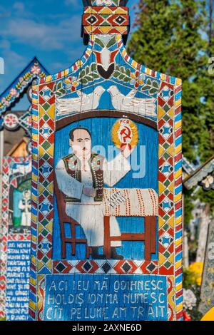 Geschnitzte Holztafeln mit Epitaphen, einschließlich Sichel und Hammer, Kreuz auf Grab, Merry Cemetery (Cimitirul Vesel) in Sapanta, Maramures, Rumänien Stockfoto