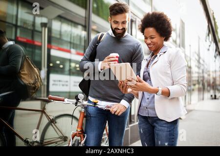 Geschäftsleute sprechen draußen mit Kaffee, Pausenerholungszeitkonzept. Stockfoto