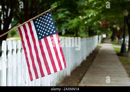 Kleine amerikanische Fahne an einem Dickicht Zaun in einer kleinen Stadt Stockfoto