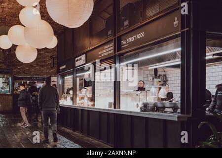 London, Großbritannien - 26. November 2019: Reihe von Imbissständen im Camden Market, London, Menschen gehen vorbei. Der Camden Market wurde 1974 mit 16 Ständen gegründet Stockfoto