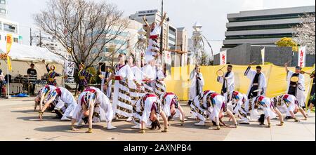 Japanische Yosakoi-Tanzgruppe tanzt auf dem öffentlichen Platz beim Kyusyu Gassai Festival in Kumamoto. Tänzerinnen, die in weißen Yukata-Jacken auftreten. Stockfoto