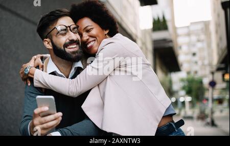 Glückliches Liebespaar. Fröhlicher junger Mann und Frau, die zusammen Spaß in der Stadt haben Stockfoto