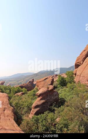 Red Rock Sandstein Wanderweg auf der Trading Post Trail in Red Rocks Park, Colorado, USA, mit Scheuerbürste, Gräser und Bäume innerhalb der Roc wächst Stockfoto