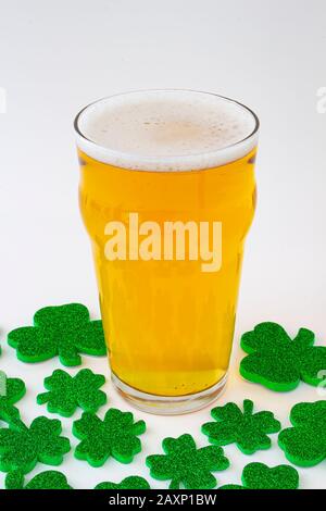 Ein Pint Bier mit grünen Kleeblättern Stockfoto