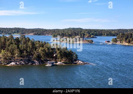 Zerklüftete Natur mit bewaldeten Inseln und felsigen Klippen im Stockholmer Archipel. Unbewohnte Inselchen, Gemeinden und uraltes Dorf mit Häusern und kleinen Stockfoto