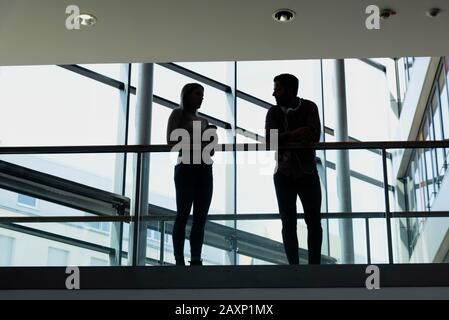 Junge Frau und junger Mann im modernen Bürogebäude machen Pause Stockfoto