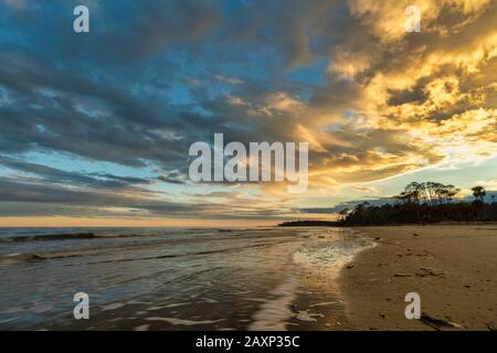 Wunderschönes Licht reflektiert auf den Wolken, während die Sonne im Hunting Island State Park auf St. Helena Island in South Carolina untergeht. Stockfoto