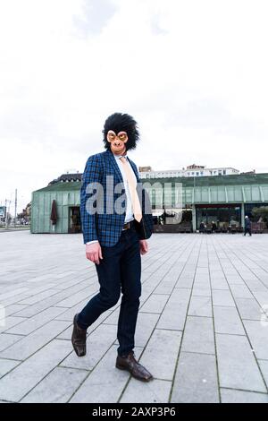 Geschäftsmann mit Affenmaske in der Stadt Stockfoto