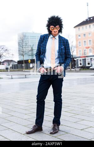 Geschäftsmann mit Affenmaske in der Stadt Stockfoto