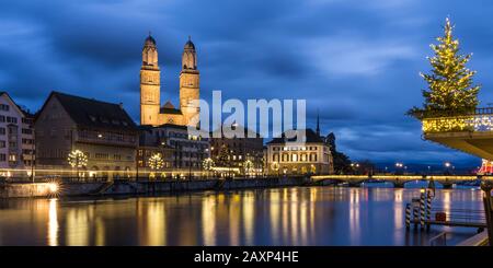 Grossmünster und Limmat mit Weihnachtsbaum zur blauen Stunde in Zürich Stockfoto