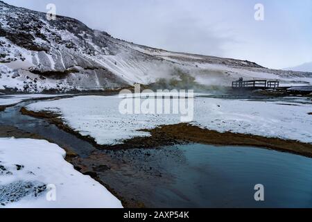 Warmes Flusswasser und Berge im Schnee in krysuvik seltun auf der Halbinsel reykjanes in der Winterlandschaft Islands. Stockfoto