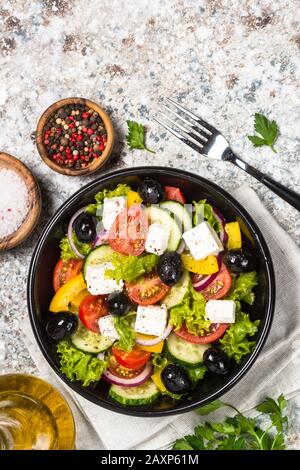 Griechischer Salat in schwarz Teller auf dem Tisch. Stockfoto