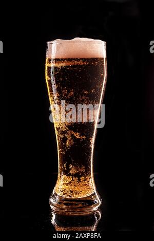 Glas helles Bier auf dunklem Hintergrund. Komplettes Glas mit Lagerbier, Nahaufnahme Stockfoto