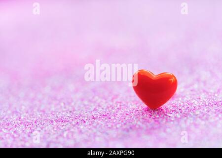 Valentines Day Hintergrund mit Red Heart Shapes auf abstraktem hellrosa Glitzerhintergrund, Copy Space Stockfoto