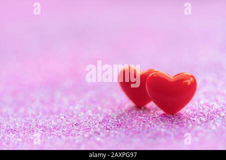 Valentines Day Hintergrund mit Red Heart Shapes auf abstraktem hellrosa Glitzerhintergrund, Copy Space Stockfoto