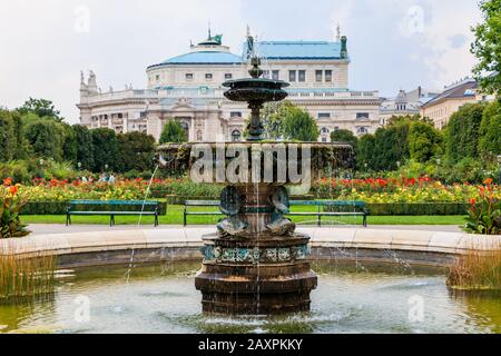 Wien, Österreich - 1. September 2019: Brunnen im Volksgarten in Wien mit Blick auf das Staatstheater Burgtheater, Österreich Stockfoto