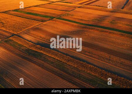 Farbenfrohen Landschaft patchwork Hintergrund, landwirtschaftlich genutzte Feld als abstraktes Muster im Herbst Sonnenuntergang, Luftaufnahme von Drone pov Stockfoto