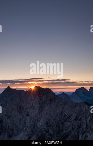 Sonnenaufgang von der westlichen Karwendelspitze, Sonnenstern hinter dem Wörner Stockfoto
