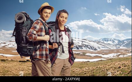 Junger Kerl und Mädchen wandern mit Rucksäcken auf dem Berg Shara mit Schnee, Mazedonien Stockfoto