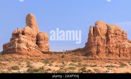 Wanderer gegen blauen Himmel am Turret Arch im Arches National Park Stockfoto