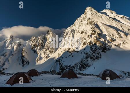 Camp mit Zelten in einer Höhe schneebedeckten Bergkulisse, Himalaya Stockfoto