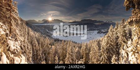 Sonnenaufgang über den Karwendel, im Vordergrund der verschneite Gerold See / Wagenbrüchsee bei Garmisch-Partenkirchen im Winter. Stockfoto