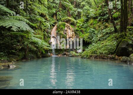 Die blaue Lagune des natürlichen heißen Frühlings in Caldeira Velha, wo Menschen in warmem Wasser auf der Insel Sao Miguel, den Azoren, Portugal schwimmen Stockfoto