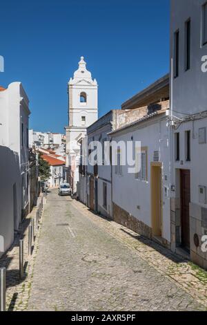 Gasse in der Altstadt mit Blick auf die Kirche Igreja de Santo Antonio, Lagos, Algarve, Bezirk Faro, Portugal Stockfoto
