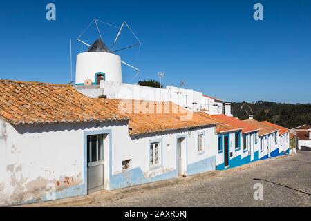 Windmühle und bunte Häuser in Odeceixe, Costa Vicentina, Algarve, Bezirk Faro, Portugal Stockfoto