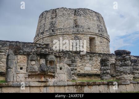 Mayapan, Yucatan, Mexiko: El Templo Redondo - der runde Tempel - mit alten Maya-Schnitzereien im Vordergrund. Stockfoto